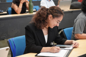 Female student smiling while taking notes