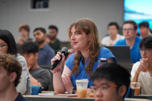 Student holding a mic asking questions during Q&A